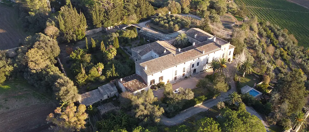 Luftaufnahme einer mallorquinischen Possessió mit Nebengebäuden, Terrassen und Pool